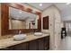 Bathroom vanity with double sinks, granite counters, and a large mirror framed with decorative wood trim at 4200 N Miller Rd # 408, Scottsdale, AZ 85251