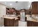 Spacious kitchen boasts granite countertops, stainless steel appliances, and dark wood cabinets at 4200 N Miller Rd # 408, Scottsdale, AZ 85251