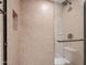 Shower with tan-tiled walls, glass door, and convenient in-wall niche at 4200 N Miller Rd # 408, Scottsdale, AZ 85251