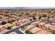 Spacious neighborhood with single-story homes, desert landscaping, and a lush green golf course in the distance at 42076 W Colby Dr, Maricopa, AZ 85138