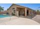 Backyard featuring a pool with desert landscaping, covered patio and block wall at 42076 W Colby Dr, Maricopa, AZ 85138