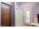 Bathroom features a glass shower, neutral tile and lighting, and a linen closet at 42076 W Colby Dr, Maricopa, AZ 85138