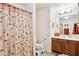 Bathroom with shower curtain, vanity, and fixtures, creating a cozy and functional space at 42076 W Colby Dr, Maricopa, AZ 85138