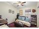 Cozy bedroom with a futon, desk, and ceiling fan, creating a comfortable and functional space at 42076 W Colby Dr, Maricopa, AZ 85138