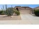 Charming home with desert landscaping, a two-car garage, and a well-maintained lawn at 42076 W Colby Dr, Maricopa, AZ 85138