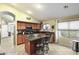 Beautiful kitchen with wooden cabinetry, granite countertops, island seating, and modern appliances at 42076 W Colby Dr, Maricopa, AZ 85138