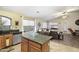 Modern kitchen with stainless steel appliances, granite countertops, and an island overlooking living area at 42076 W Colby Dr, Maricopa, AZ 85138