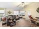 Spacious living room features a leather sectional, tile floors, and bright natural light at 42076 W Colby Dr, Maricopa, AZ 85138