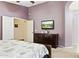 Primary bedroom boasts soft purple walls, tile floor, and a doorway to the Primary bathroom at 42076 W Colby Dr, Maricopa, AZ 85138