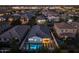 Aerial view of a home with a pool, turf lawn, and outdoor seating at dusk at 4346 S Synapse Dr, Mesa, AZ 85212