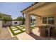 Beautiful backyard with covered patio, travertine pavers, fireplace and artificial turf at 4346 S Synapse Dr, Mesa, AZ 85212