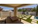 Comfortable patio overlooking backyard with fireplace, pool and stone/turf design; great for entertaining guests at 4346 S Synapse Dr, Mesa, AZ 85212