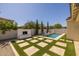 Relaxing backyard featuring an outdoor fireplace, a pool, and stone/turf design; perfect for outdoor enjoyment at 4346 S Synapse Dr, Mesa, AZ 85212