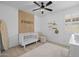 Bedroom featuring an 'Everett' accent wall, white crib, shuttered windows, and a ceiling fan at 4346 S Synapse Dr, Mesa, AZ 85212