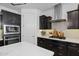 Modern kitchen featuring dark cabinetry, quartz countertops, stainless steel appliances, and designer tile backsplash at 4346 S Synapse Dr, Mesa, AZ 85212