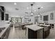 Open-concept kitchen boasts a large island, stainless steel appliances, dark cabinets, and a seamless flow to the living area at 4346 S Synapse Dr, Mesa, AZ 85212