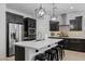 Modern kitchen features dark cabinetry, stainless steel appliances, a large island, and pendant lighting at 4346 S Synapse Dr, Mesa, AZ 85212