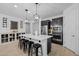Beautiful kitchen island with black stools and modern pendant lighting, stainless steel appliances, and wine racks at 4346 S Synapse Dr, Mesa, AZ 85212
