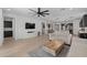 Spacious living room features wood-look tile flooring, a ceiling fan, and an open layout with adjacent kitchen at 4346 S Synapse Dr, Mesa, AZ 85212