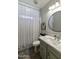 Cozy bathroom with a single sink, white quartz countertop, round mirror, and shower/tub combo at 4524 E Narrowleaf Dr, Gilbert, AZ 85298