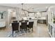 Open-concept dining area featuring a modern chandelier, a gray dining table, and views into the kitchen at 4524 E Narrowleaf Dr, Gilbert, AZ 85298