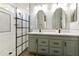Modern bathroom with a dual sink vanity, framed mirrors, and a walk-in shower with elegant tile at 4524 E Narrowleaf Dr, Gilbert, AZ 85298