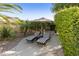 Relaxing patio space with striped chaise lounges and a privacy wall of lush greenery at 4524 E Narrowleaf Dr, Gilbert, AZ 85298