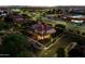 Nighttime aerial shot of a lit-up home, emphasizing its curb appeal and position within a well-lit neighborhood at 5016 S Curie Way, Mesa, AZ 85212