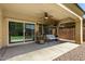 Back patio features a swing, seating, ceiling fan and covered area for outdoor relaxation and entertaining at 5016 S Curie Way, Mesa, AZ 85212