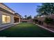 Beautiful backyard with lush green grass, mature landscaping, and a covered patio, creating a serene outdoor oasis at 5016 S Curie Way, Mesa, AZ 85212