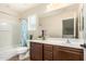 Bathroom features dark wood vanity, double sinks, large mirror, shower-tub combo and stylish decor at 5016 S Curie Way, Mesa, AZ 85212