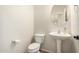 Powder bathroom with white pedestal sink, toilet, and oval mirror at 5016 S Curie Way, Mesa, AZ 85212