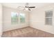 Bright bedroom features neutral walls, plush carpet, ceiling fan and natural light from the double windows at 5016 S Curie Way, Mesa, AZ 85212