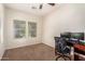 Bedroom features neutral walls, plush carpet, ceiling fan and natural light from the double windows at 5016 S Curie Way, Mesa, AZ 85212