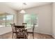 Bright dining area with a glass table, seating for four, and natural light from the window at 5016 S Curie Way, Mesa, AZ 85212