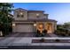 Exterior front view of a two-story house featuring a two-car garage and a covered porch with inviting outdoor seating at 5016 S Curie Way, Mesa, AZ 85212
