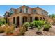 Inviting two-story home with a terracotta tile roof, arched entryways, and beautiful landscaping at 5016 S Curie Way, Mesa, AZ 85212