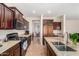 Traditional kitchen featuring granite countertops, dark wood cabinets, and stainless steel appliances at 5016 S Curie Way, Mesa, AZ 85212