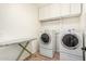 Laundry Room features a front load washer and dryer, storage cabinets, and an ironing board at 5016 S Curie Way, Mesa, AZ 85212