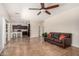 Open-concept living room with tile floors, ceiling fan, adjacent to kitchen with breakfast bar at 5016 S Curie Way, Mesa, AZ 85212