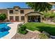 Expansive backyard featuring a sparkling pool, lush lawn, and covered patio for outdoor relaxation and entertaining at 5437 W Red Bird Rd, Phoenix, AZ 85083