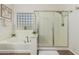 Relaxing bathroom featuring a soaking tub with a glass block window and a separate glass-enclosed shower at 5437 W Red Bird Rd, Phoenix, AZ 85083