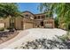 Beige stucco two-story home featuring an arched entryway, desert landscaping, and a 3-car garage with ample parking at 5437 W Red Bird Rd, Phoenix, AZ 85083