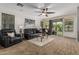 Cozy living room with leather furniture, ceiling fan, and view of the backyard at 5437 W Red Bird Rd, Phoenix, AZ 85083