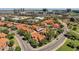 Community aerial view showing red-tiled roofs, mature trees, winding roads, and the city skyline in the background at 609 E Mesquite Cir # D132, Tempe, AZ 85288