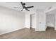 Bedroom with neutral walls, ceiling fan, wood-look flooring, and closet at 609 E Mesquite Cir # D132, Tempe, AZ 85288
