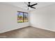 Bedroom with neutral walls, ceiling fan, and a large window at 609 E Mesquite Cir # D132, Tempe, AZ 85288