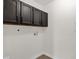 Utility room with neutral walls, flooring, and dark upper cabinets at 609 E Mesquite Cir # D132, Tempe, AZ 85288