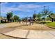 Community playground featuring multiple swings, slides, and a climbing structure in a park setting at 609 E Mesquite Cir # D132, Tempe, AZ 85288
