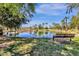 Scenic pond in a community park, surrounded by lush trees, palm trees and grassy banks with a resting bench at 609 E Mesquite Cir # D132, Tempe, AZ 85288